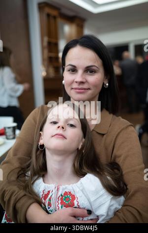Vertikales Foto einer liebevollen Mutter mittleren Alters und ihrer Tochter in Vyshyvanka, emotionales Familienbindungskonzept Stockfoto
