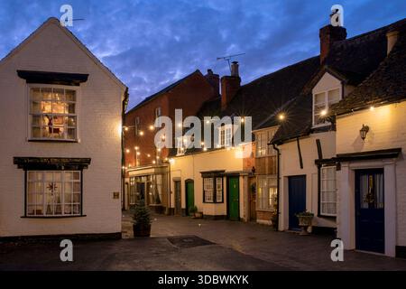 Weihnachtsbeleuchtung entlang der Butterstraße in der Abenddämmerung. Alcester, Warwickshire, England Stockfoto