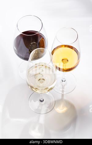 Verschiedene Weingläser auf weißem Hintergrund, elegante Weinkomposition Stockfoto