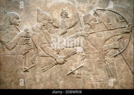 Assyrisches Steinrelief aus dem achten Jahrhundert v. Chr., das Soldaten in der Schlacht darstellt, Palastmauer aus dem antiken Mesopotamien, die Kriegsführung, Bogenschützen und schild zeigt Stockfoto