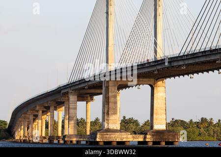 Seilbrücke über den Fluss mit Betonkonstruktion in städtischer Landschaft Stockfoto