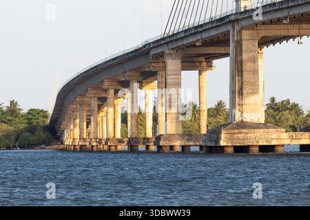 Seilbrücke über den Fluss mit Betonkonstruktion in städtischer Landschaft Stockfoto