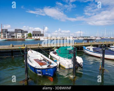 Kleine Motorboote im Hafen von Kerteminde mit Häusern am Wasser entlang der Nordre Havnekaj im Hintergrund, Fünen, Süddänemark Stockfoto