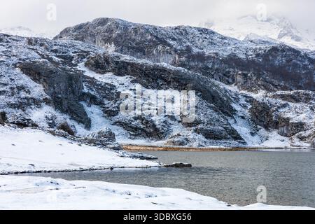 Gletschersee Ercina im Winter, umgeben von schneebedeckten Bergen. Die Seen von Covadonga, Nationalpark Picos de Europa, Asturien, Spanien. Stockfoto