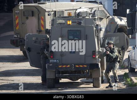 Nablus, Palästina. Dezember 2025. Ein israelischer Soldat richtet seine Waffe während eines Überfalls auf das Flüchtlingslager Askar östlich von Nablus im Westjordanland. Israelische Truppen plünderten palästinensische Häuser und Geschäfte im Lager auf der Suche nach palästinensischen Militanten. Ein Palästinenser wurde bei der Suche verletzt. Quelle: SOPA Images Limited/Alamy Live News Stockfoto