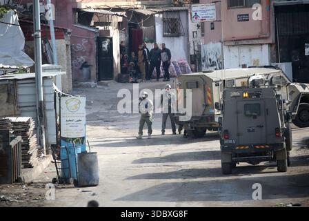 Nablus, Palästina. Dezember 2025. Israelische Soldaten bewachen Militärfahrzeuge und nehmen Positionen bei einem Angriff auf das Flüchtlingslager Askar östlich von Nablus in der Westbank ein. Israelische Truppen plünderten palästinensische Häuser und Geschäfte im Lager auf der Suche nach palästinensischen Militanten. Ein Palästinenser wurde bei der Suche verletzt. Quelle: SOPA Images Limited/Alamy Live News Stockfoto