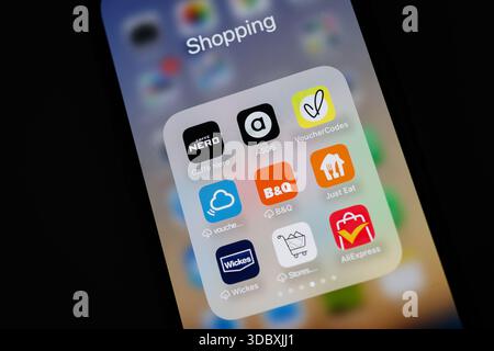 Nahaufnahme eines iPhone Smartphone-Bildschirms mit verschiedenen Shopping- und Rabattanwendungen, die in einem Ordner mit der Bezeichnung Shopping Aliexpress B&Q wickes organisiert sind Stockfoto