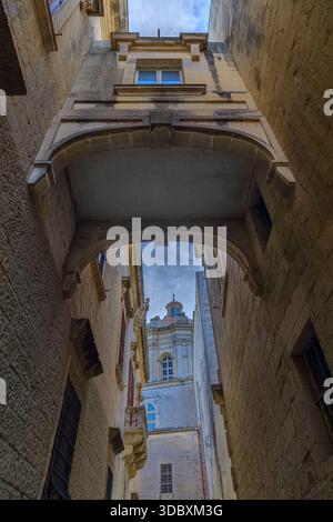 Typisches Stadtbild von Mdina, Malta: Blick auf die Bastion Street mit der Kuppel der St. Paul's Cathedral im Hintergrund. Stockfoto