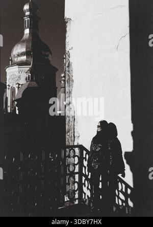 KIEW, Ukraine 13. Dezember 2025 ikonischer Blick auf einen Kiew-Petschersk Lavra Komplex. Eine Frau in der Nähe von historischen Kuppeln und historischer Architektur mit dramatischer Architektur Stockfoto