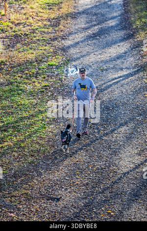 Washington, DC - Ein Mann geht mit seinem Hund auf dem Kingman Island Trail spazieren. Kingman Island liegt im Anacostia River. Stockfoto