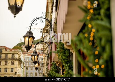 Lissabon Portugal 05. Dezember 2025 Straßenlaternen und Weihnachtsgirlanden schmücken Gebäudefassaden im Stadtzentrum Stockfoto