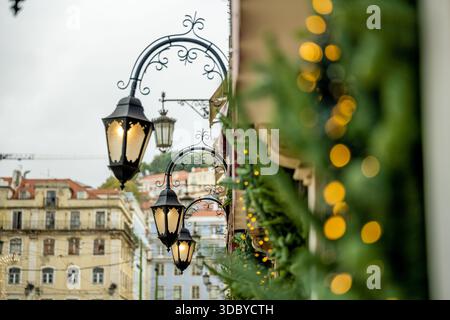 Lissabon Portugal 05. Dezember 2025 Straßenlaternen mit festlichen Girlanden säumen das Äußere historischer Gebäude Stockfoto