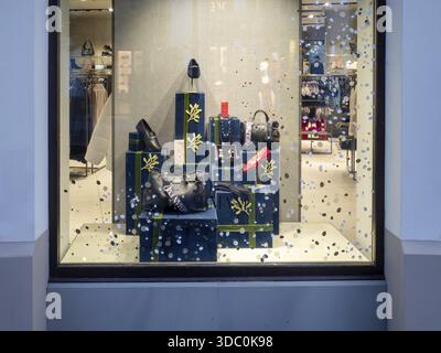Ein luxuriöses Schaufenster mit Geschenkboxen und Modeaccessoires in Schwarz- und Grüntönen, Fidenza, Italien, 6. Dezember 2025 Stockfoto