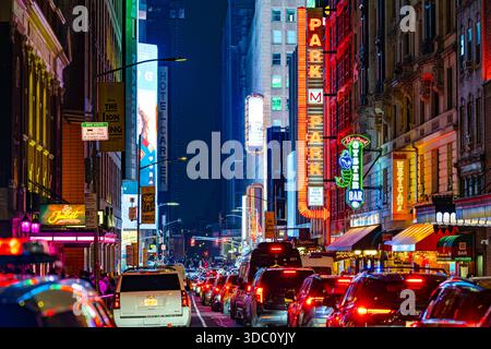 Nachtverkehr auf einer neonbeleuchteten Straße im Theaterviertel Broadway, New York City Stockfoto