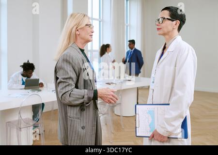 Frau mittleren Alters im Gespräch mit einem jungen erwachsenen weiblichen Arzt Stockfoto