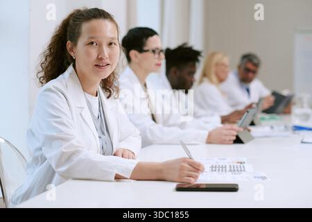 Porträt einer jungen erwachsenen asiatischen Frau, die mit diversen medizinischen Teams im Büro arbeitet Stockfoto