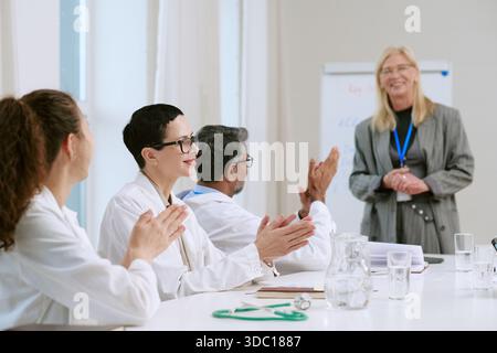 Diverse Gruppe von Medizinern mittleren Alters applaudieren Seniorinnen Stockfoto