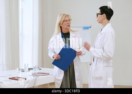 Frau mittleren Alters und junge Erwachsene Frau diskutieren Forschung Stockfoto