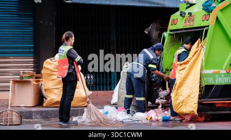 Bangkok, Thailand, 19. November 2025: Arbeiter reinigen die Straßen von Chinatown fleißig, sammeln Müll und pflegen die geschäftige städtische Umgebung Stockfoto