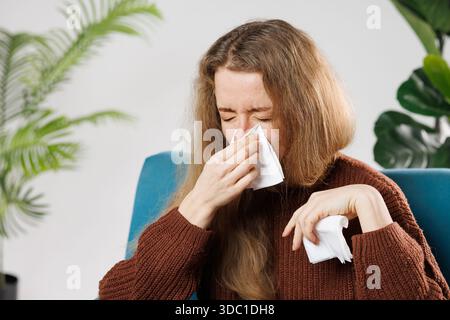 Erkältung und Grippe. Portrait von kranken Frau Kalt erwischt, Krankheitsgefühl und Niesen in Papier abwischen. Nahaufnahme des Schönen ungesunde Mädchen Fallen in der Decke Stockfoto