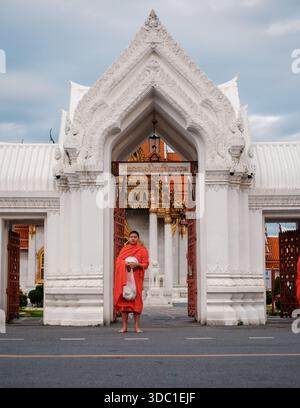 Bangkok, Thailand, 19. November 2025. Wunderschöner Eingang zum Wat Benchamabophit mit einem Mönch in Fornt of Stockfoto