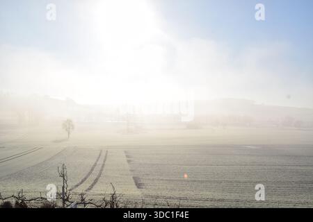 Neuschnee auf den Feldern mit Nebel darüber Stockfoto