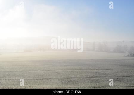 Neuschnee auf den Feldern mit Nebel darüber Stockfoto