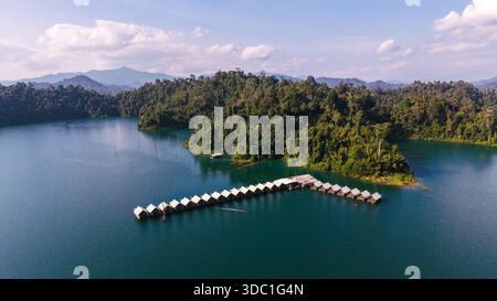 Im Herzen des Khao Sok Nationalparks gelegen, besticht der Cheow Lan Lake mit seinem atemberaubenden smaragdgrünen Wasser und seinen dramatischen Kalksteinformationen. Schwimmendes Bungalow-Floß Khao Sok Thailand Stockfoto