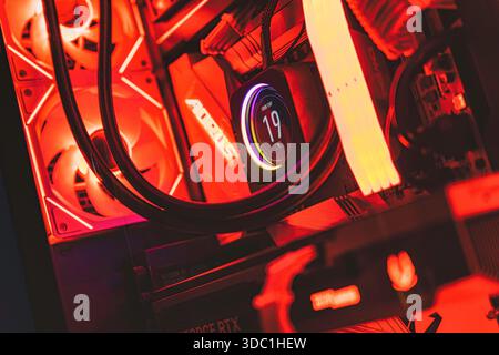 Rovigo, italien 18. dezember 2025: Hochleistungs-Computerkomponenten, beleuchtet mit leuchtend roter rgb-Beleuchtung, die fortschrittliche Flüssigkeitskühlungssysteme bieten Stockfoto