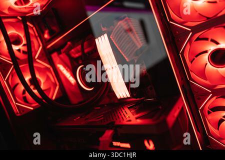 Rovigo, italien 18. dezember 2025: Hochleistungs-Computer-Setup, das interne Komponenten mit leuchtend rotem rgb-Licht, das digitale Technol reflektiert, anzeigt Stockfoto