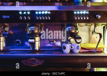 Rovigo, italien 18. dezember 2025: Kommerzielle Espressomaschine von wega für die Zubereitung von zwei Tassen Kaffee mit beleuchtetem Bedienfeld und Edelstahl Stockfoto