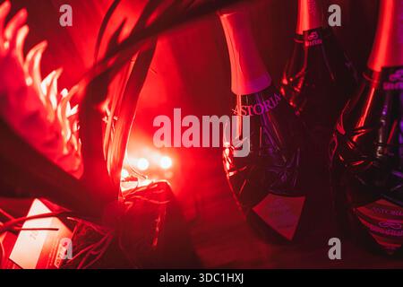 Rovigo, italien 18. dezember 2025: Flaschen astoria Sekt, beleuchtet durch leuchtendes rotes Licht, schaffen eine Party- und Feiertagsatmosphäre Stockfoto