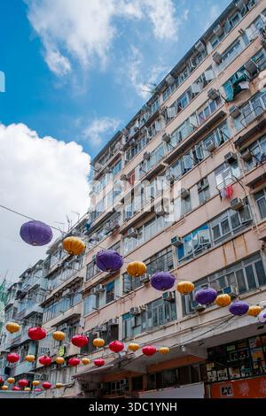 Laternen, die unter dem alten Wohnhaus in Hongkong aufgereiht sind Stockfoto