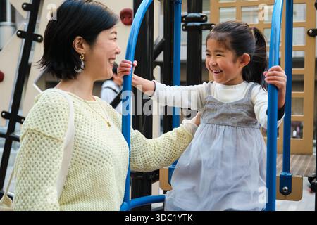 Asiatische Mutter und Tochter haben Spaß auf dem Spielplatz in Japan Stockfoto
