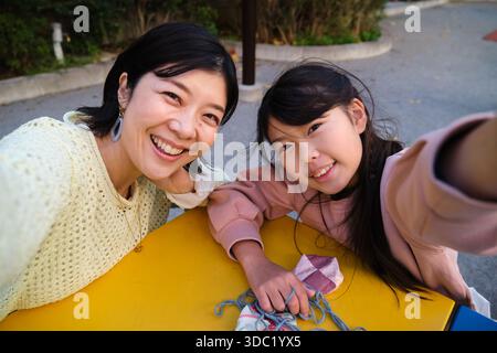 Japanische Mutter Tochter macht Selfie zusammen lächelnd Stockfoto