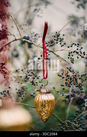 Vintage-weihnachtsschmuck aus Kiefernkegel aus Glas hängt von der Pflanze Stockfoto