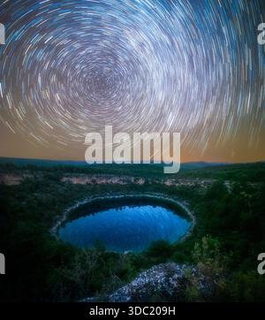 Zirkumpolar Star Trails über Mountain Lagoon mit Reflexionen im Wasser Stockfoto