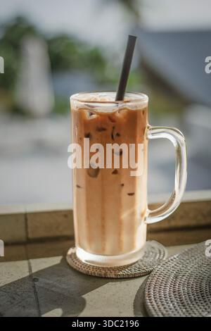 Ein großes Glas Eiskaffee steht auf einem Tisch Stockfoto