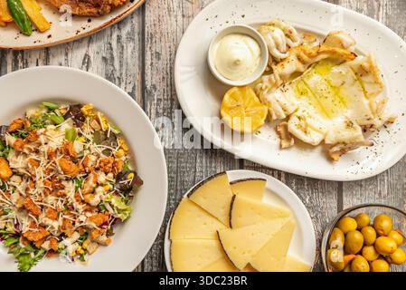 Gegrillter Tintenfisch mit sautiertem Gemüse, begleitet von hausgemachten Aioli und gerösteten, in der Pfanne gebratenen Scheiben zum Dippen Stockfoto