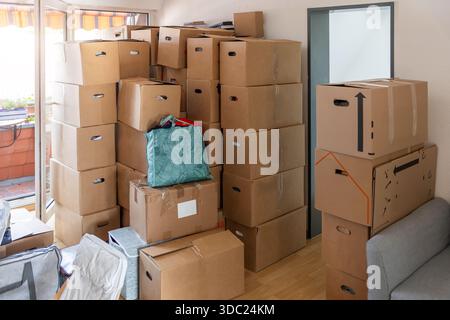 Gepackte Wohnzimmerinnenausstattung gefüllte, stapelbare Kartonschachteln persönliche Gegenstände Möbel, die den Umsiedlungsprozess zeigen, Haushaltsübergang. Bewegen Stockfoto