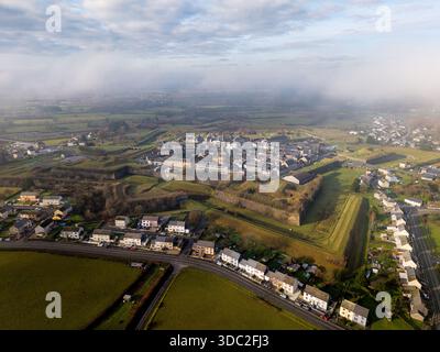 Hohe, weite Luftaufnahme des sternförmigen Festungsturms von Rocroi, Frankreich, mit seinem vollständigen Layout und den umliegenden tief hängenden Wolken Stockfoto