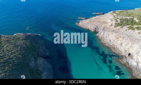 Blick auf die abgeschiedene türkisfarbene Bucht mit Klippen und kristallklarem Meer Stockfoto