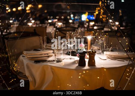 Zürich, Schweiz, 17. Dezember 2025. Eleganter Esstisch in einem schicken Restaurant am Abend. Weitwinkel, Nahaufnahme, geringe Tiefe der Feile, Stockfoto
