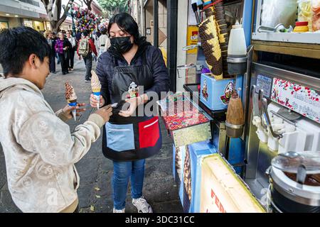 Puebla Mexico, Calle 5 Cinco de Mayo, Straßenverkäufer, Eisständer, Softeis, Waffelkegel, Erwachsene Frau, Frau, Straßenverkäufer, tragendes Gesicht Stockfoto