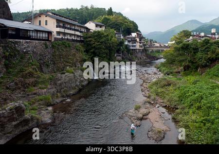 Der Fluss Yoshida fließt an einem trüben Sommertag durch die Bergstadt Gujo-Hachiman (郡上八幡) in der Präfektur Gifu, Japan. Stockfoto
