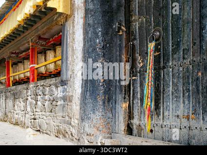 Ein Teil eines buddhistischen Klosters mit Gebetsmühlen und traditioneller Architektur. Stockfoto