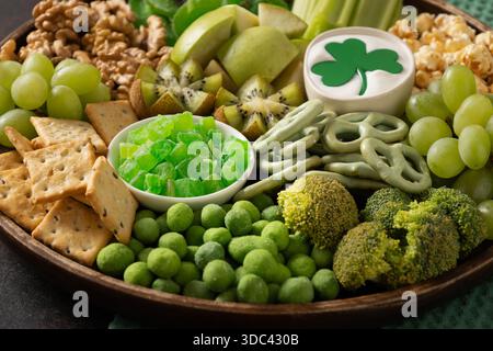 Grüne Snackplatte mit Obst, Gemüse und knusprigen Snacks, die für die Feierlichkeiten am St. Patrick's Day und festliche Partygerichte arrangiert werden. Stockfoto