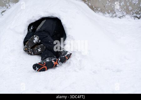 Person, die in einem Schneeloch schläft oder sich versteckt. Hochwertige Fotos Stockfoto