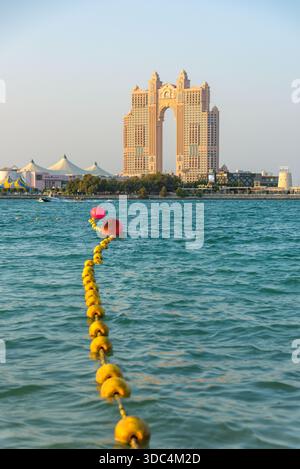 Abu Dhabi, VAE - 24. November 2025: Die majestätische Architektur des Rixos Marina Hotels dominiert den Horizont und strahlt in warmen Licht Stockfoto