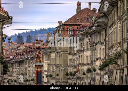 Festliche Kiefern an mittelalterlichen Fassaden an der historischen Kramgasse in der Nähe des Samson-Brunnens, der Altstadt oder der Altstadt während des Weihnachtsmarktes in Bern, Schweiz Stockfoto